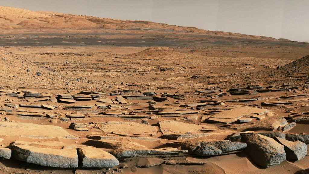 Image 2: Gale Crater, Mars, where the hydrogen-forming process has been inferred. The fine-grained rocks in the foreground record the quiescent waters of an ancient lake, while in the distance, a great hill of more rock awaits exploration.